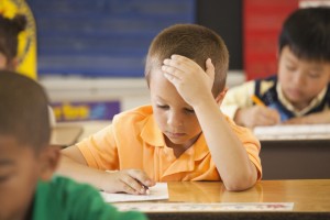 Caucasian student studying at desk in classroom
