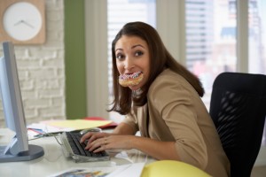 Anxious Woman Eating While Working on Her Computer